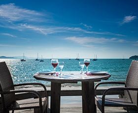 Taças de vinho servidas em uma mesa frente ao mar de Jurerê
